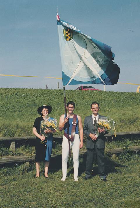 Nur zwei Fahnen in hundert Jahren: Nachdem die alte Fahne beim Unwetter am Turnfest in Kleindöttingen 1990 beschädigt worden war, weihte man im Rahmen des 25-Jahr-Jubiläums des Eichwaldfests 1992 eine neue ein. Von links: Gotte Getrud Hossli, Fahnenträger Jürg Riner und Götti Alois Huber. Foto: zVg